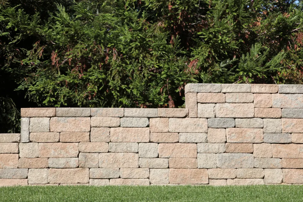 Stacked concrete block retaining wall in a landscaped yard in Nassau County, NY — Nassau County Concrete