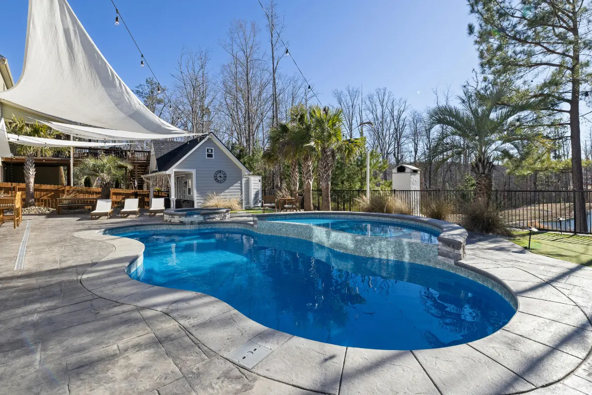 Stamped concrete pool deck around a freeform pool in Nassau County, NY — Nassau County Concrete